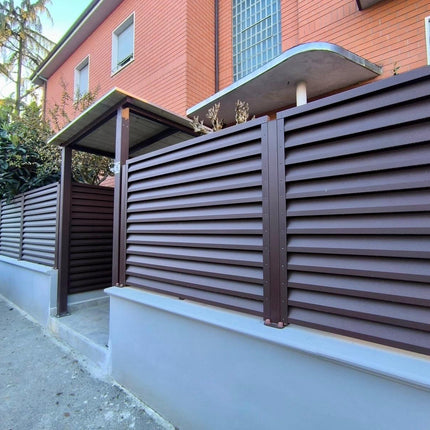 dettaglio recinzione giardino con installazione frangivista in acciaio zincato effetto cioccolato colore marrone su piloni esistenti