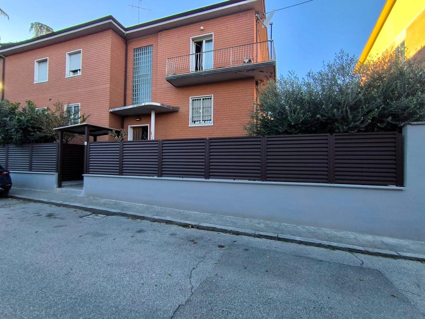 sezione laterale della recinzione giardino con installazione frangivista in acciaio zincato effetto cioccolato colore marrone su piloni esistenti