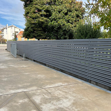 Installazione perimetrale lunga con steccato orizzontale per giardino esterno con doghe in acciaio zincato colore grigio grafite, progetto completato